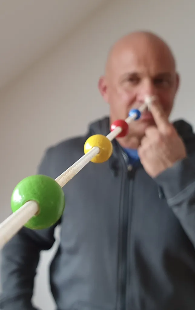 Martin AIber bei einer Augentraining-Übung mit bunten Kugeln auf einem Stab